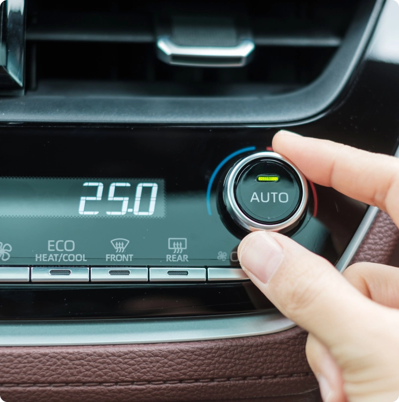 Hand adjusting the automatic climate control temperature in a car