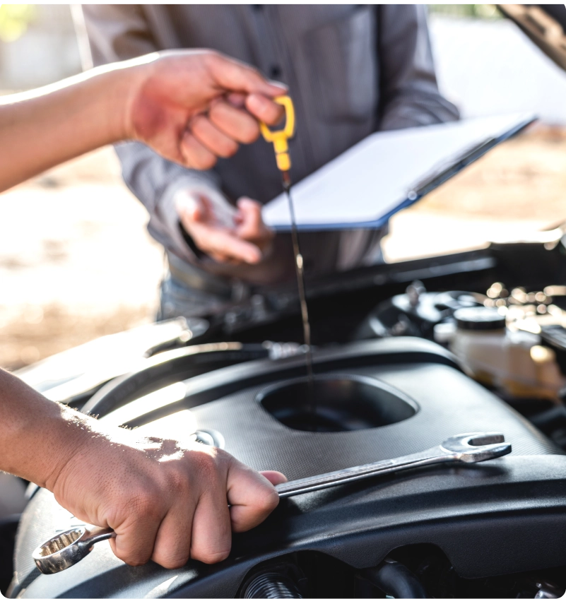 Technician checking engine oil with a dipstick